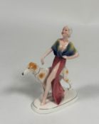 Katzhutte, a German porcelain Art Deco figure of a lady walking a borzoi hound, green printed