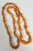 A single strand graduated "butterscotch" amber bead necklace, the tubular beads with small oval