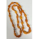 A single strand graduated "butterscotch" amber bead necklace, the tubular beads with small oval