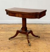 A handsome George IV ebony and brass inlaid mahogany foldover card table, of bowed breakfront