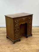 A George III mahogany knee-hole desk, circa 1760, the top with ebony string inlay and a deep cross