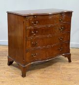 An Edwardian mahogany serpentine chest of Hepplewhite design, the book matched and cross banded