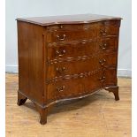 An Edwardian mahogany serpentine chest of Hepplewhite design, the book matched and cross banded