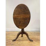 A Georgian mahogany tilt top table, mid 18th century, the circular top tilting on a bird cage, above