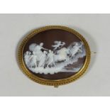 A 19th century shell cameo brooch, the oval plaque carved to depict Aurora being drawn in her