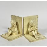 A pair of composition bookends with seated girl figures reading, (16cm x 13cm x 12.5cm)