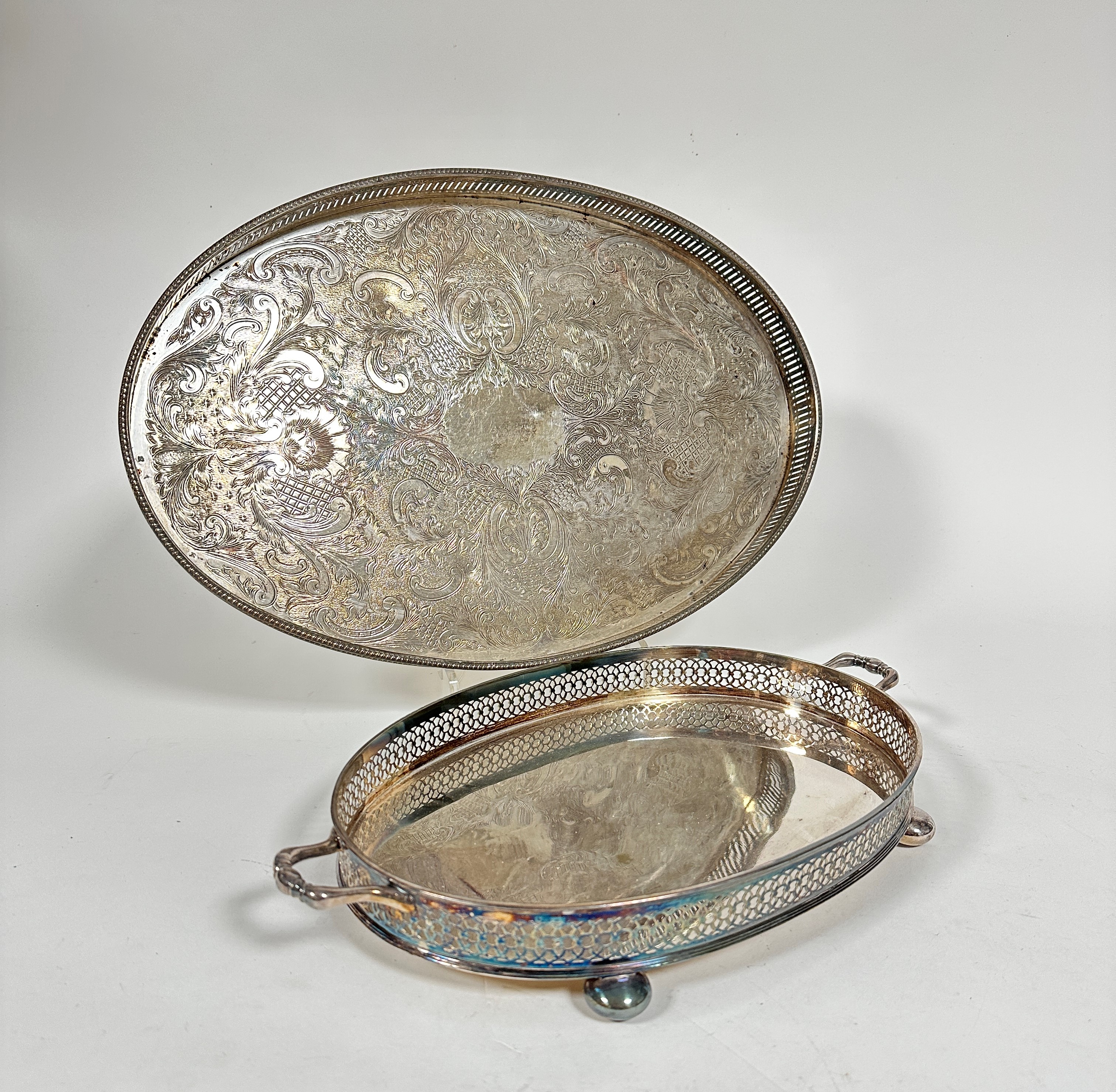 An Epns two handled pierced galleried tray raised on bun feet, (h 5cm x 32cm x 22cm) and an Epns