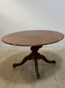 A Victorian walnut loo table, the oval top raised on baluster turned column and four scroll carved
