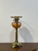 A late Victorian floral and spiral cast brass oil lamp with moulded cranberry glass reservoir,