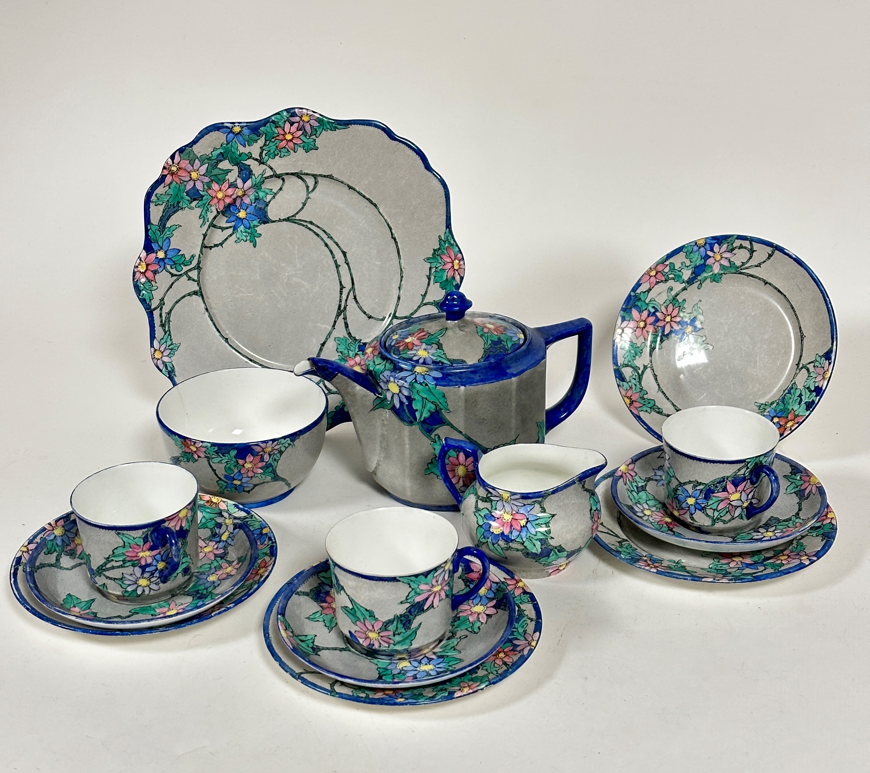 A fourteen piece 1920s tea set with handpainted floral scrolling leaf design with blue reserves