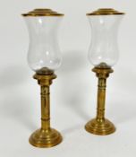A pair of brass turned column storm lanterns with shaped glass shades, complete with domed cover, (