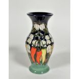 A Moorcroft baluster vase decorated with chili pepper and flower tube-lined design, with blue and