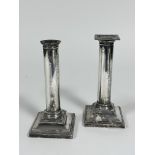 A pair of Edwardian Sheffield silver cast candlesticks of column form on stepped bases with reeded