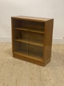 A mid century teak bookcase, the sliding glass doors enclosing two adjustable shelves, on a