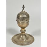 An Eastern white metal pierced egg shaped incense burner with hinged top and a ball finial raised on