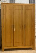 A contemporary light hardwood triple wardrobe, the interior fitted with shelves and for hanging,