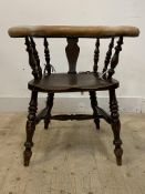 A Smokers bow type stained oak armchair, early 20th century, with faux leather upholstered back