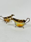 A pair of Birmingham 1938 silver George III style scalloped sauce boats with C scroll handle to