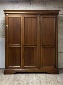 Willis and Gambier, A stained hardwood triple wardrobe, the interior fitted with drawers and for