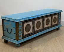 An eastern style blue painted hardwood blanket box, the panelled front with brass mounts, raised