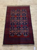 A New Baluchi rug, the red field with gul motif, 133cm x 86cm