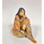A Spanish Lladro pottery figure of a seated Mexican lady draped with shawl and moccasins,