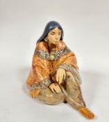 A Spanish Lladro pottery figure of a seated Mexican lady draped with shawl and moccasins,