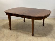 An Edwardian mahogany wind out extending dining table, oval top with one leaf, raised on square