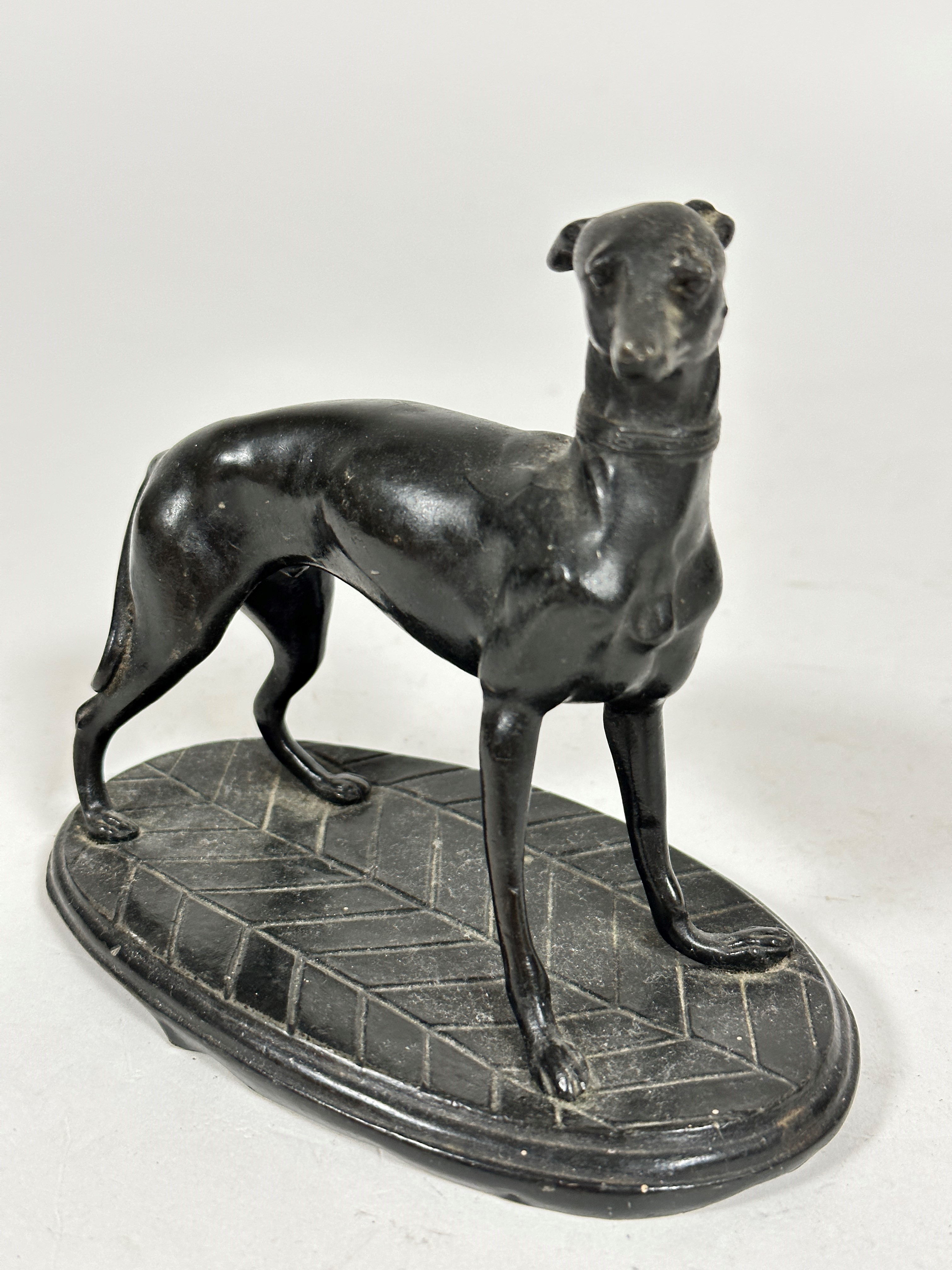 A spelter model of an Italian greyhound, raised on oval cast base, unsigned, (12cm x 13cm x 7cm)