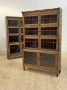 A pair of early 20th century oak four height stacking library bookcases, each tier with twin lead