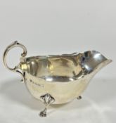 A Birmingham 1934 silver George III style scalloped sauce boat with C scroll handle raised on