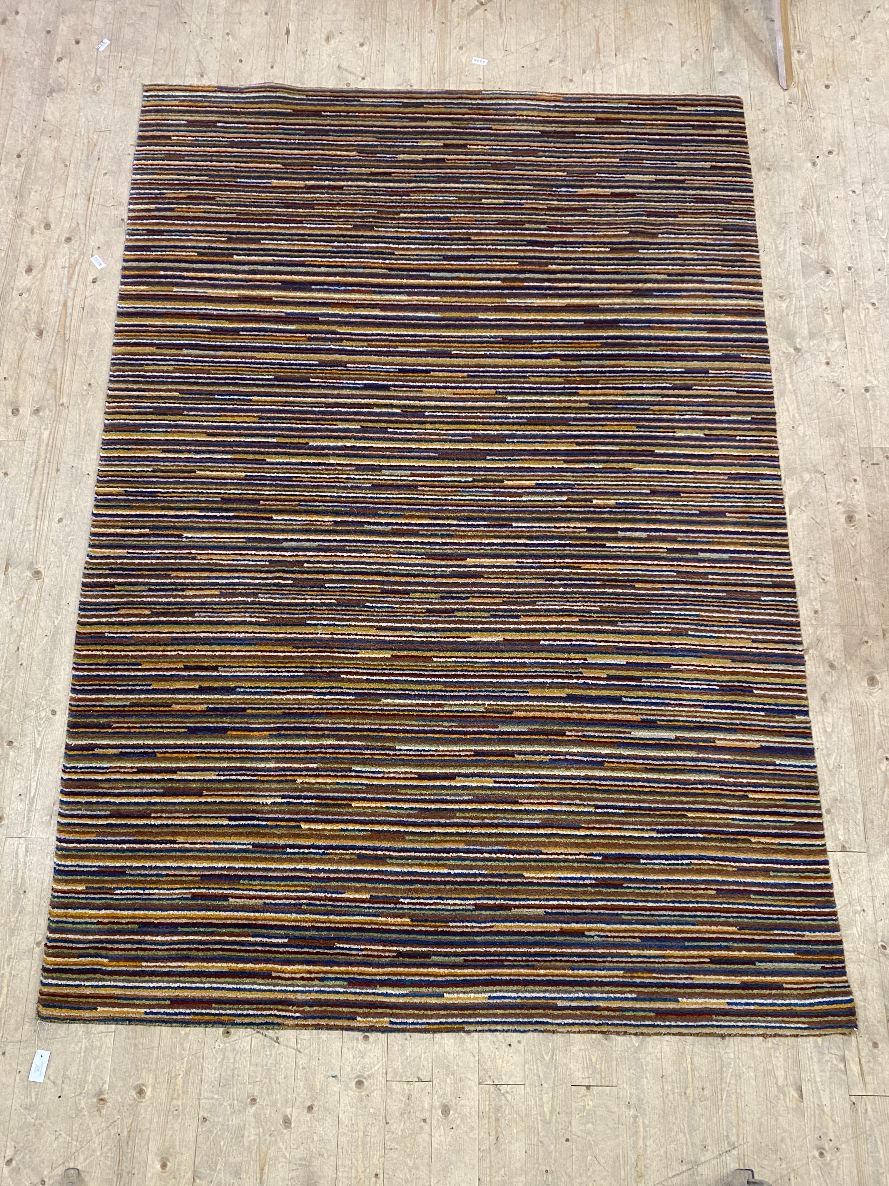 A contemporary wool pile rug of all over polychromatic lineal design, 202cm x 296cm