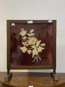 An early 20th century glazed oak fire screen, the stitched silk and velvet panel worked in a