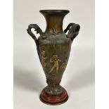 A spelter French two handled urn vase with cast cherub relief plain figures and leaf twin scroll