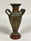 A spelter French two handled urn vase with cast cherub relief plain figures and leaf twin scroll