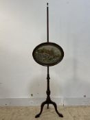 A 19th century mahogany pole screen, the oval banner embroidered with a country cottage, raised on