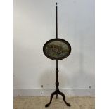 A 19th century mahogany pole screen, the oval banner embroidered with a country cottage, raised on