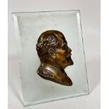 A rectangular frosted glass panel containing a plaster silhouette of Lenin with applied gilt