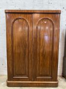 A Victorian mahogany wardrobe, the twin arched panelled doors opening to an interior fitted with