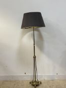 An Edwardian brass telescopic standard lamp, with three branches and raised on three scroll cast