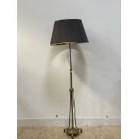 An Edwardian brass telescopic standard lamp, with three branches and raised on three scroll cast