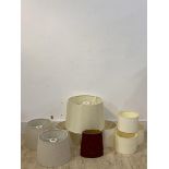 A collection of ten lamp shades of various designs and sizes