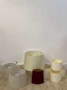 A collection of ten lamp shades of various designs and sizes