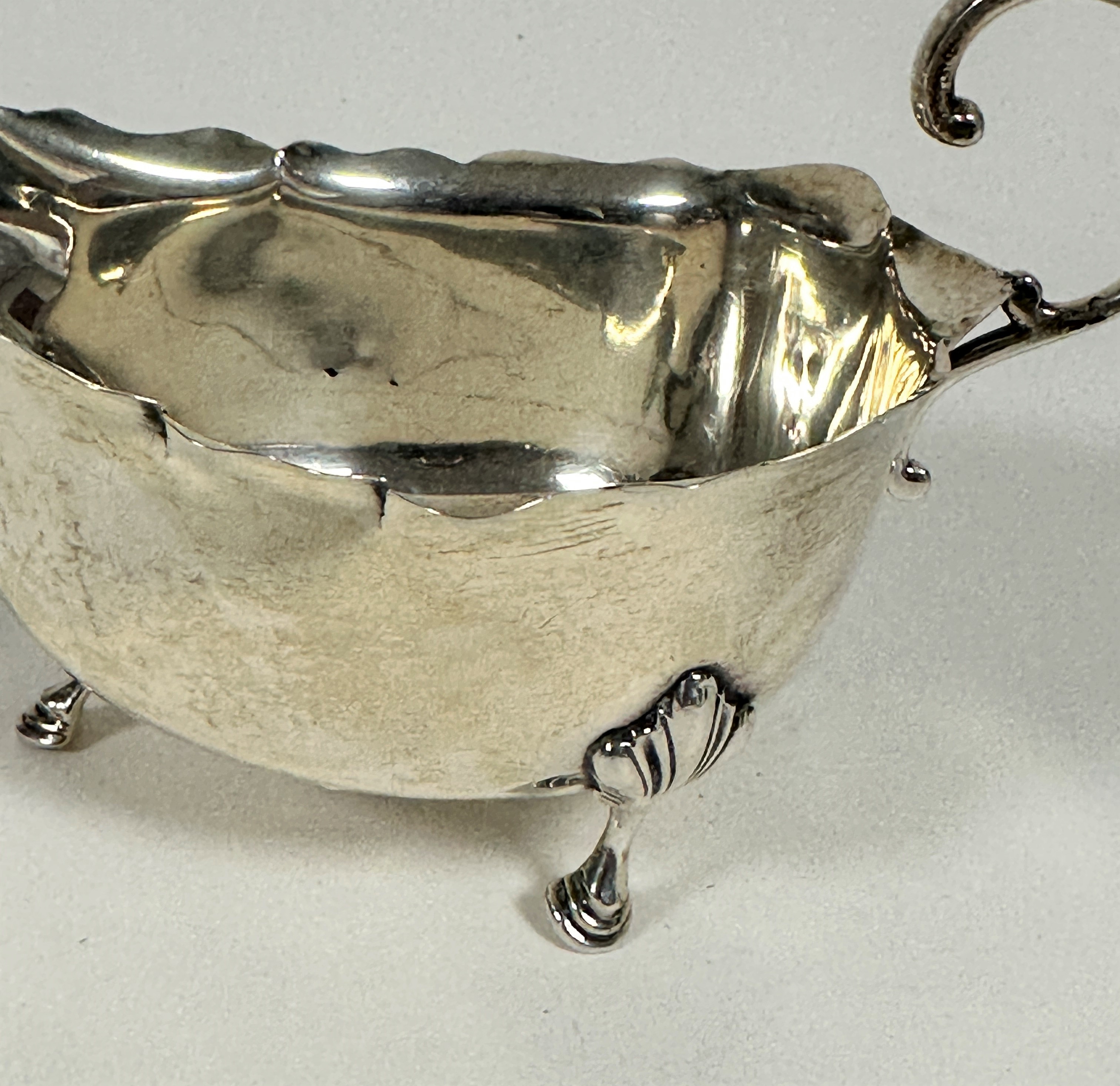 A Birmingham 1934 silver George III style scalloped sauce boat with C scroll handle raised on - Image 3 of 3