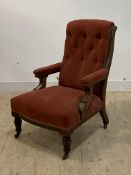 A late Victorian/Edwardian walnut framed open armchair, upholstered in red velvet on turned supports
