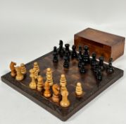 An African hardwood chess board with relief carved leaf border complete with stained ebony and beech