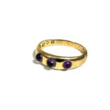 An 18ct gold gypsy ring, set three amethyst cabouchons, (l/m) (2.14g)