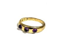 An 18ct gold gypsy ring, set three amethyst cabouchons, (l/m) (2.14g)