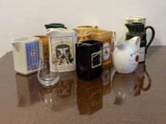A collection of 12 whiskey and alcohol branded advertising jugs, to include Beltane, Tenants,