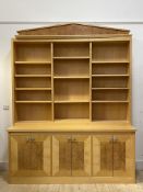 A quality bespoke satin birch and figured maple veneered bookcase, the arched top over twelve